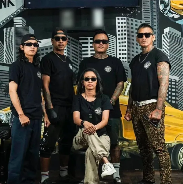 The Mr Ink Bali crew in black Mr Ink t-shirts in front of a city mural inside the Seminyak tattoo studio
