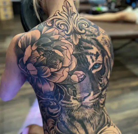 Black and grey tiger and peony back piece with ornamental filigree, tattooed at Mr Ink Bali in Seminyak